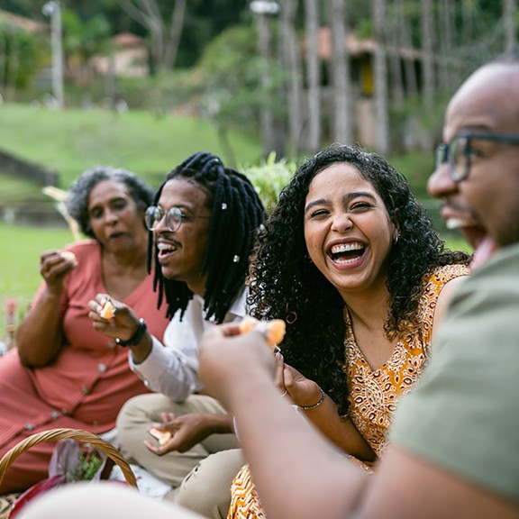 Four people sitting outside laughing together