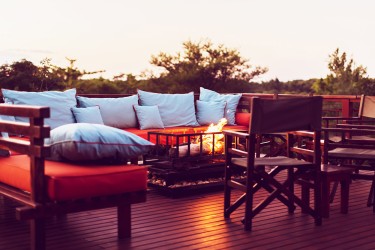 An outdoor deck with a couch and multiple chairs