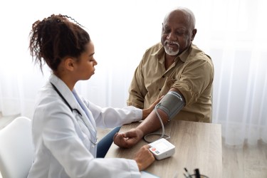 A doctor takes a blood pressure reading of a patient